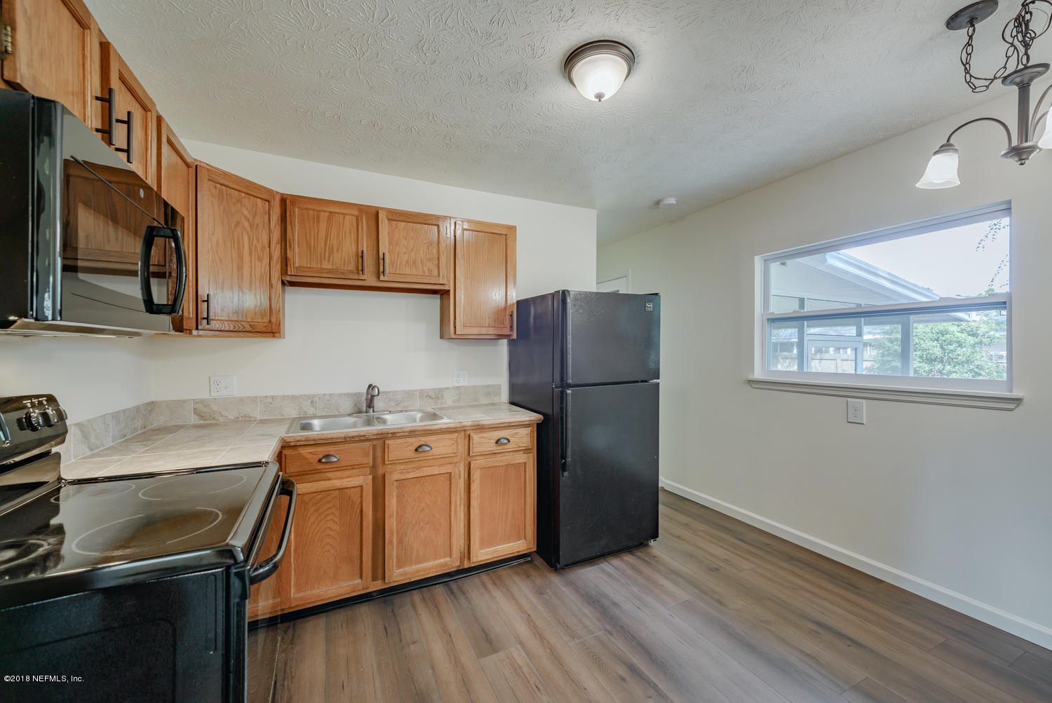 117 Tanager Road St. Augustine, FL 32086 - Photo 10 of 30 a kitchen with stainless steel appliances granite countertop a refrigerator a sink dishwasher a stove with wooden cabinets and floor