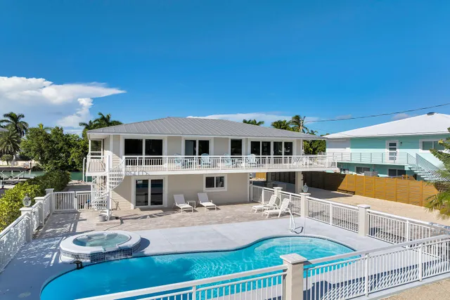a front view of a house with swimming pool garden and outdoor seating