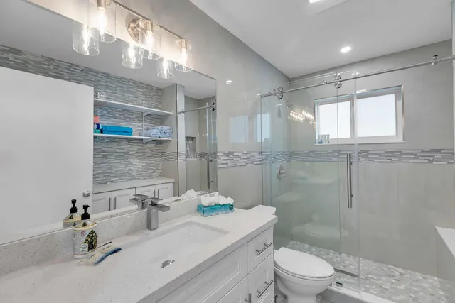 a bathroom with a sink a toilet and shower