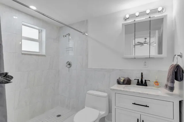 a bathroom with a shower sink vanity and toilet