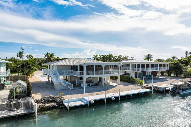 a view of a lake with lawn chairs and a potted plant