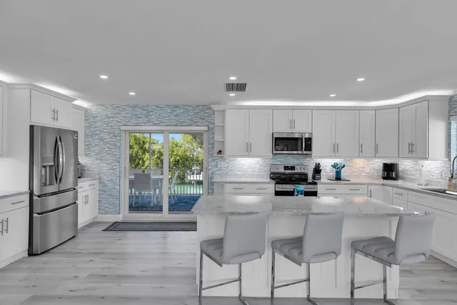 a kitchen with stainless steel appliances granite countertop a refrigerator and a stove top oven