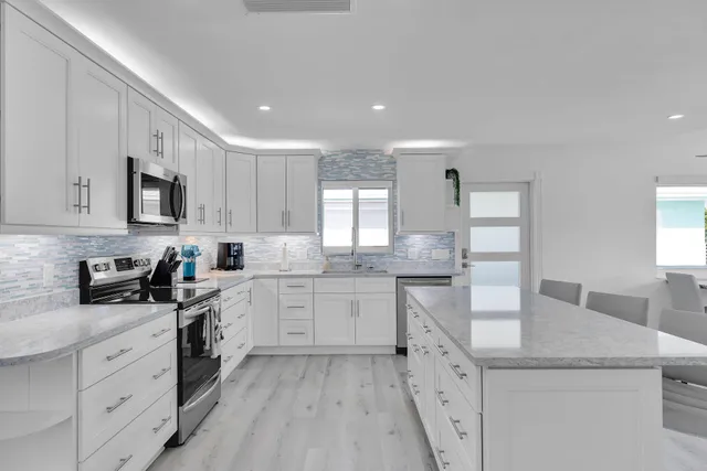 a kitchen with sink a microwave and cabinets