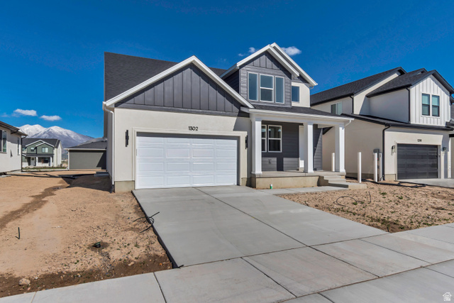 1302 1475 East, Unit 40 Payson, UT 84651 - Photo 3 of 34 View of front of home featuring a porch, board and batten siding, concrete driveway, a mountain view, and a garage