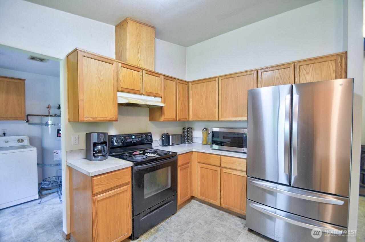 13920 Littlerock Road Southwest Rochester, WA 98579 - Photo 11 of 23 a kitchen with stainless steel appliances granite countertop a refrigerator stove and a sink