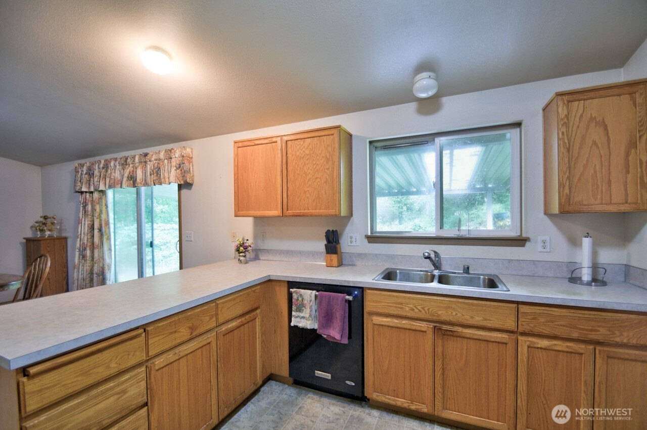 13920 Littlerock Road Southwest Rochester, WA 98579 - Photo 12 of 23 a kitchen with sink a window and cabinets
