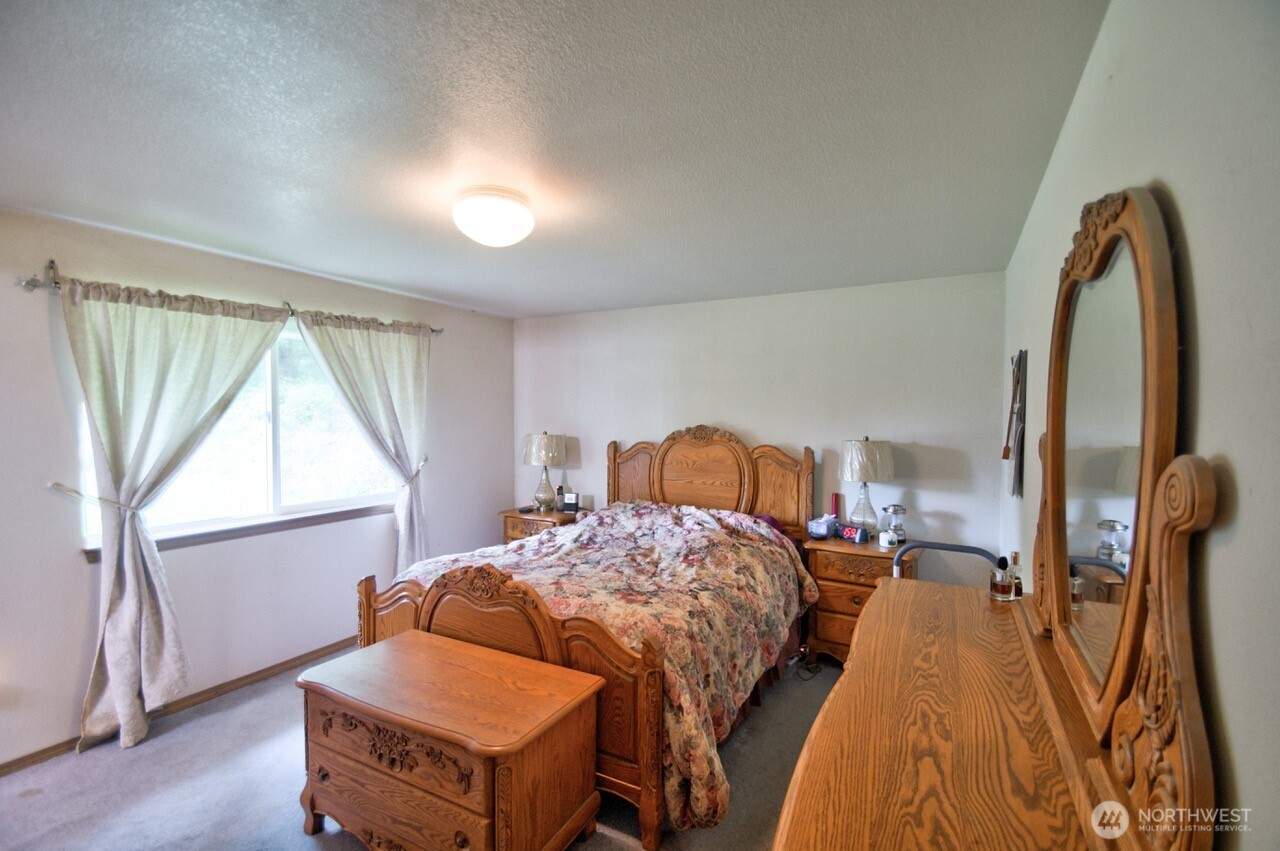 13920 Littlerock Road Southwest Rochester, WA 98579 - Photo 18 of 23 a bedroom with a bed and a window