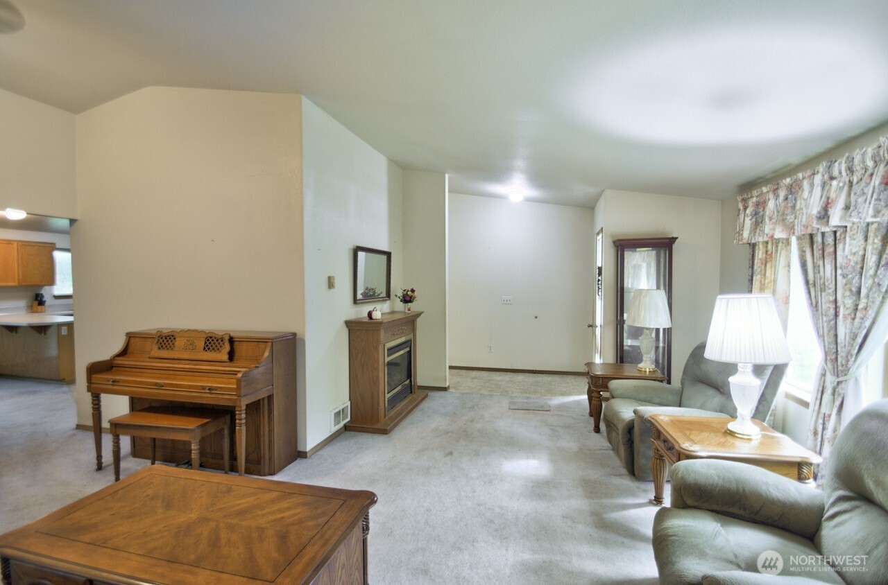 13920 Littlerock Road Southwest Rochester, WA 98579 - Photo 10 of 23 a living room with furniture a piano and a flat screen tv