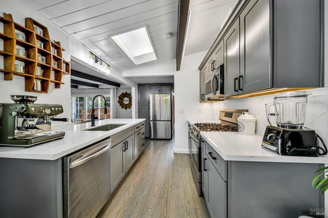 a kitchen with kitchen island granite countertop lots of counter top space and stainless steel appliances