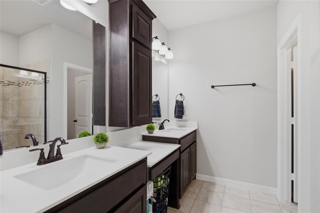 6343 Rustic Edge Street Godley, TX 76044 - Photo 20 of 37 His and her vanities with extra storage cabinet. Larger shower option was built in this home.