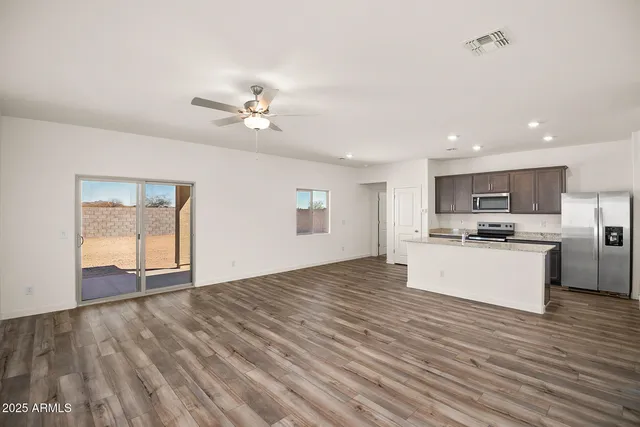 a view of kitchen with granite countertop cabinets and refrigerator