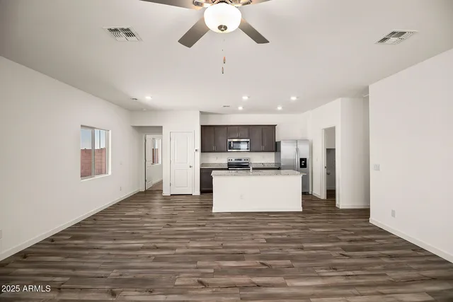 a view of kitchen with microwave a refrigerator and a stove top oven