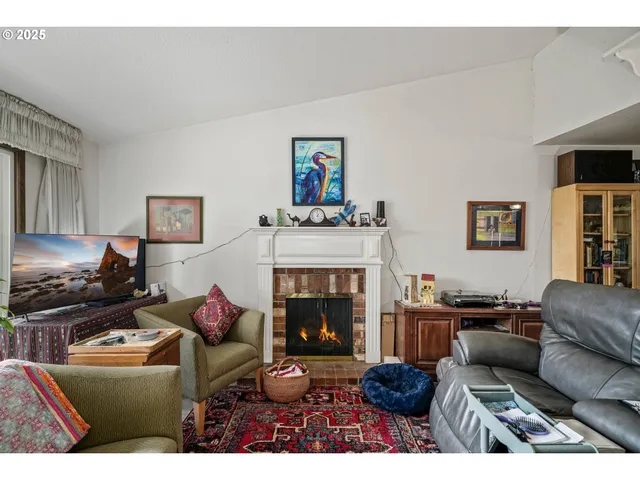 a living room with furniture a bookshelf and a window