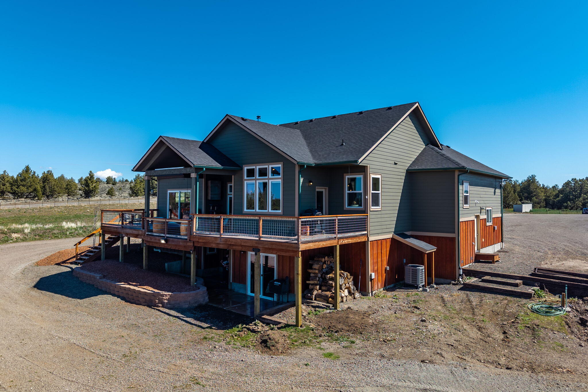 6040 Gravett Road Prineville, OR 97754 - Photo 47 of 77 a view of a house with wooden deck and a floor to ceiling windows