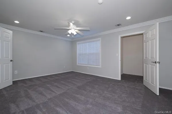 an empty room with a ceiling fan and a window
