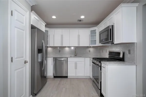 a kitchen with stainless steel appliances granite countertop a refrigerator and a stove top oven