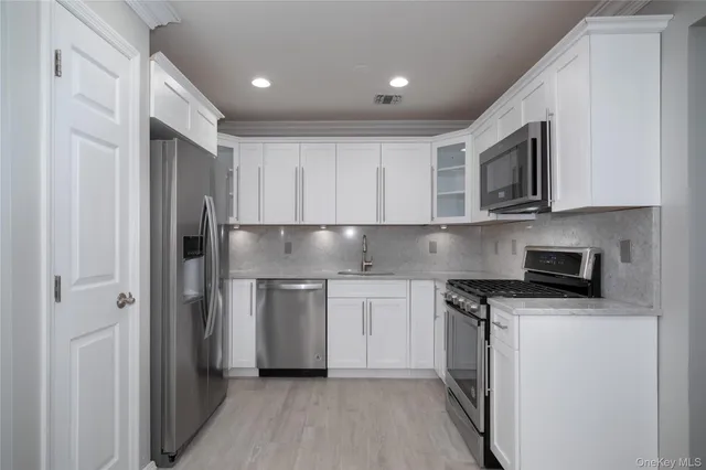 a kitchen with stainless steel appliances granite countertop a refrigerator and a stove top oven