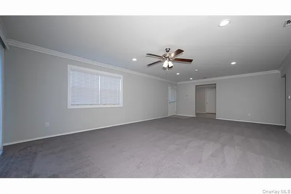 a view of an empty room with a chandelier fan