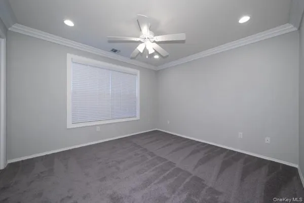 an empty room with windows and fan