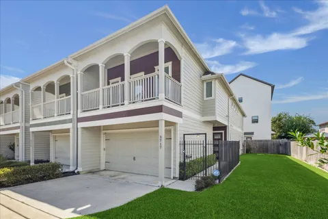 a front view of a house with a yard and potted plants