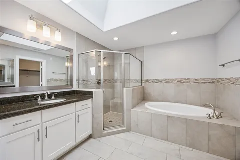 a bathroom with a bathtub shower sink vanity and toilet