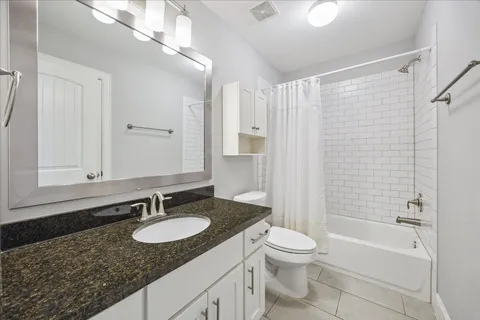 a bathroom with a granite countertop sink toilet a mirror and shower
