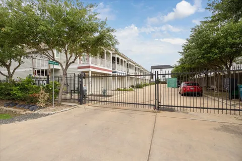 a view of a house with a small yard and a large tree