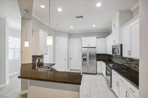 a kitchen with stainless steel appliances granite countertop a sink stove and refrigerator