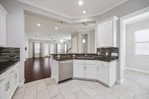 a large kitchen with granite countertop a stove sink and cabinets