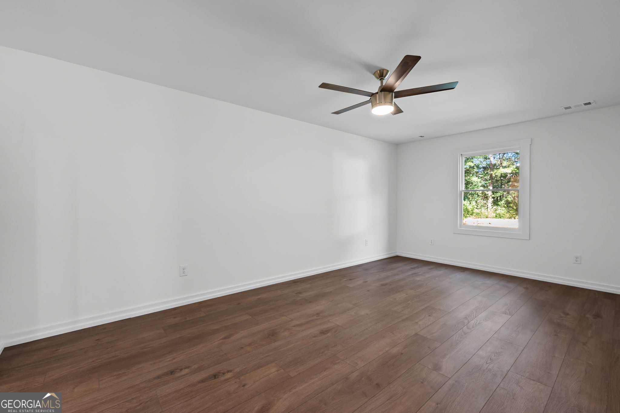 85 Franklin Road Newnan, GA 30263 - Photo 19 of 37 an empty room with wooden floor ceiling fan and windows