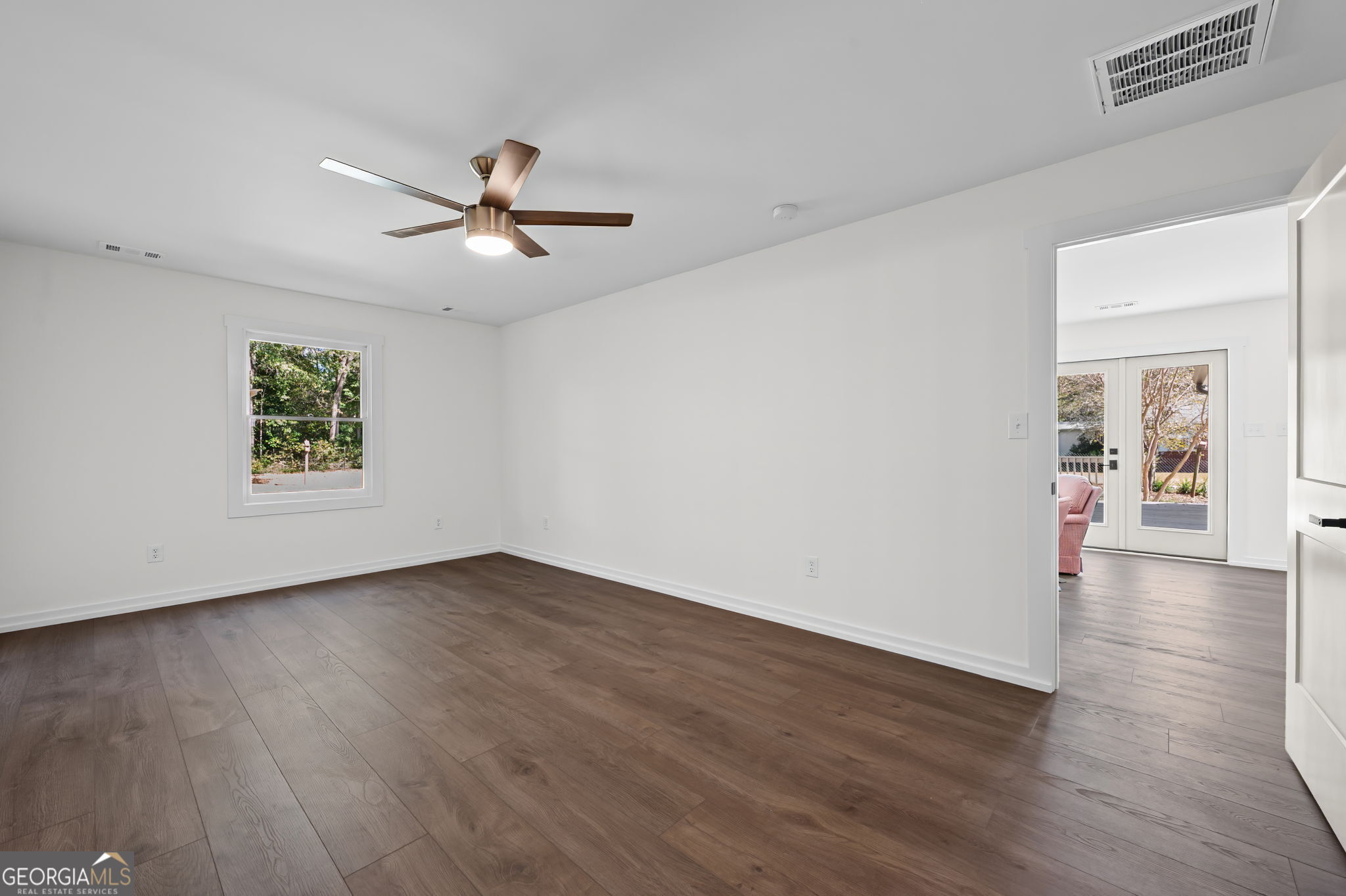 85 Franklin Road Newnan, GA 30263 - Photo 22 of 37 an empty room with wooden floor chandelier fan and windows