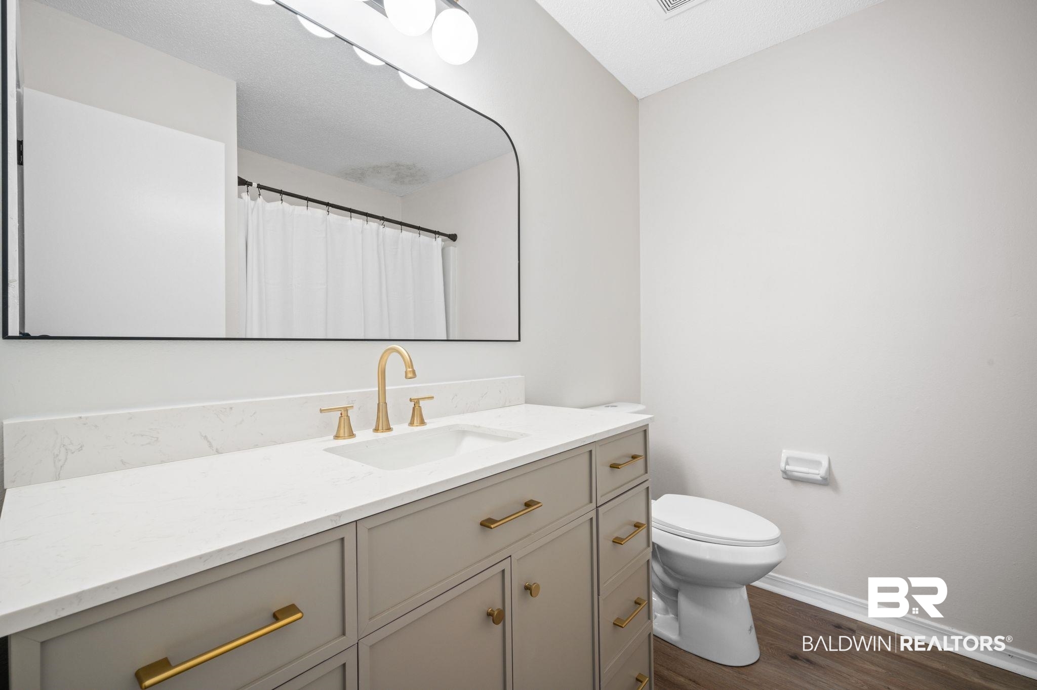 811 East Verbena Avenue Foley, AL 36535 - Photo 15 of 16 Bathroom with vanity, toilet, wood-type flooring, and walk in shower