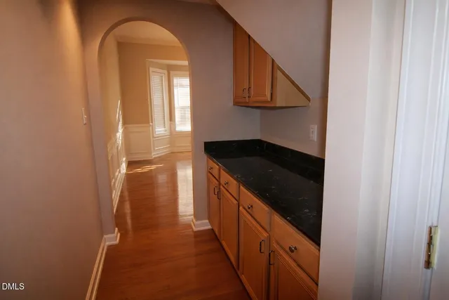 a view of empty room with wooden floor and fireplace