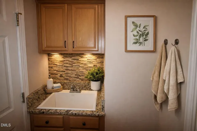 a kitchen with granite countertop a sink stove and cabinets