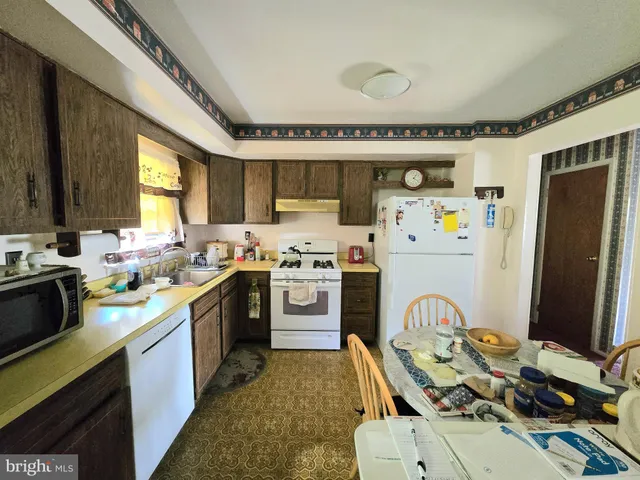 a kitchen that has a lot of cabinets a sink and appliances