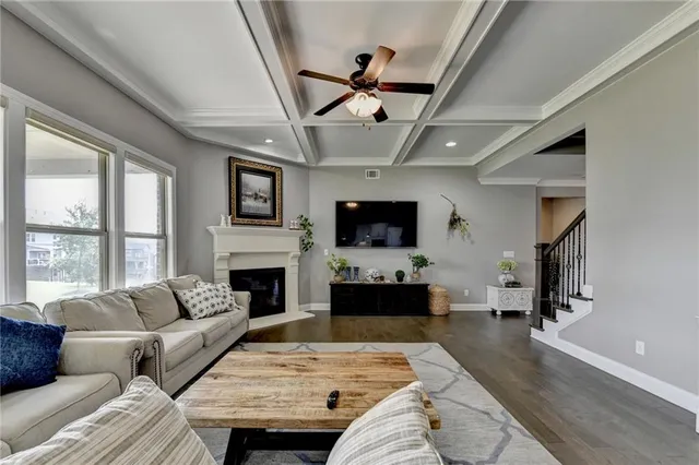 a kitchen with stainless steel appliances granite countertop a stove a refrigerator a kitchen island a dining table and chairs with wooden floor