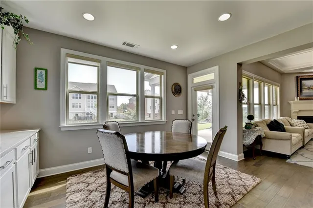 a kitchen with stainless steel appliances granite countertop a table chairs sink refrigerator and cabinets