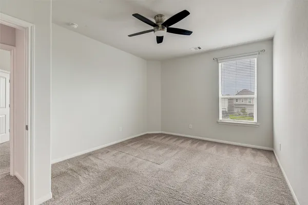 an empty room with a window and a ceiling fan