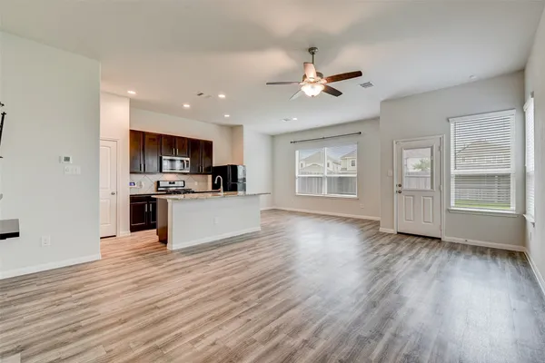 a view of kitchen with cabinets wooden floor and window