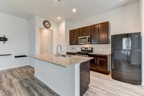 a kitchen with stainless steel appliances granite countertop a sink stove and refrigerator