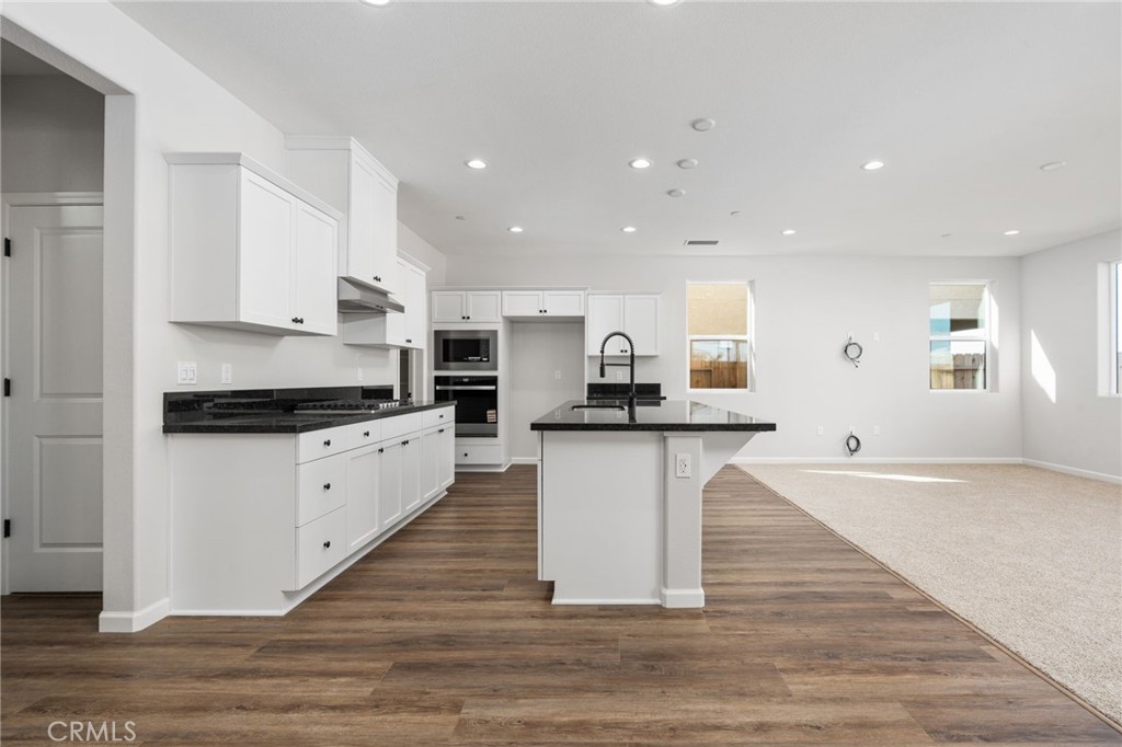 1266 Talus Way South Madera, CA 93636 - Photo 12 of 43 a kitchen with white cabinets and a sink