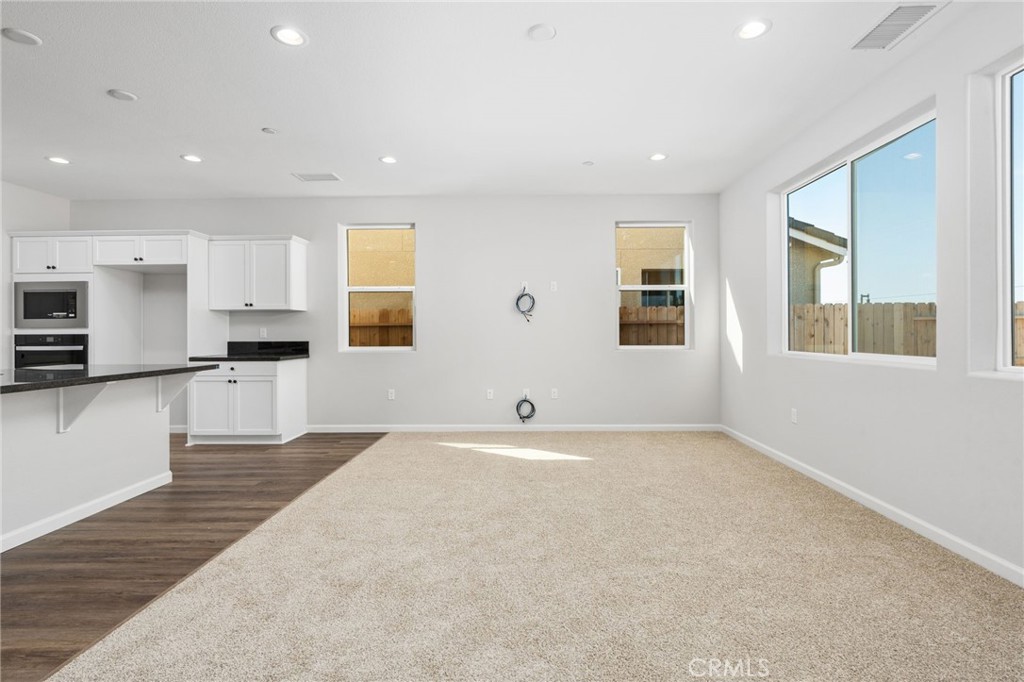 1266 Talus Way South Madera, CA 93636 - Photo 17 of 43 a view of empty room with wooden floor and kitchen