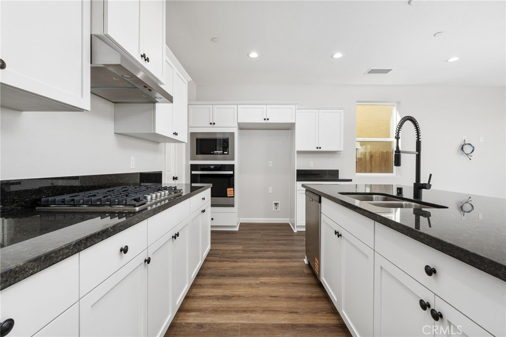 1266 Talus Way South Madera, CA 93636 - Photo 20 of 43 a large kitchen with stainless steel appliances granite countertop a stove and a sink
