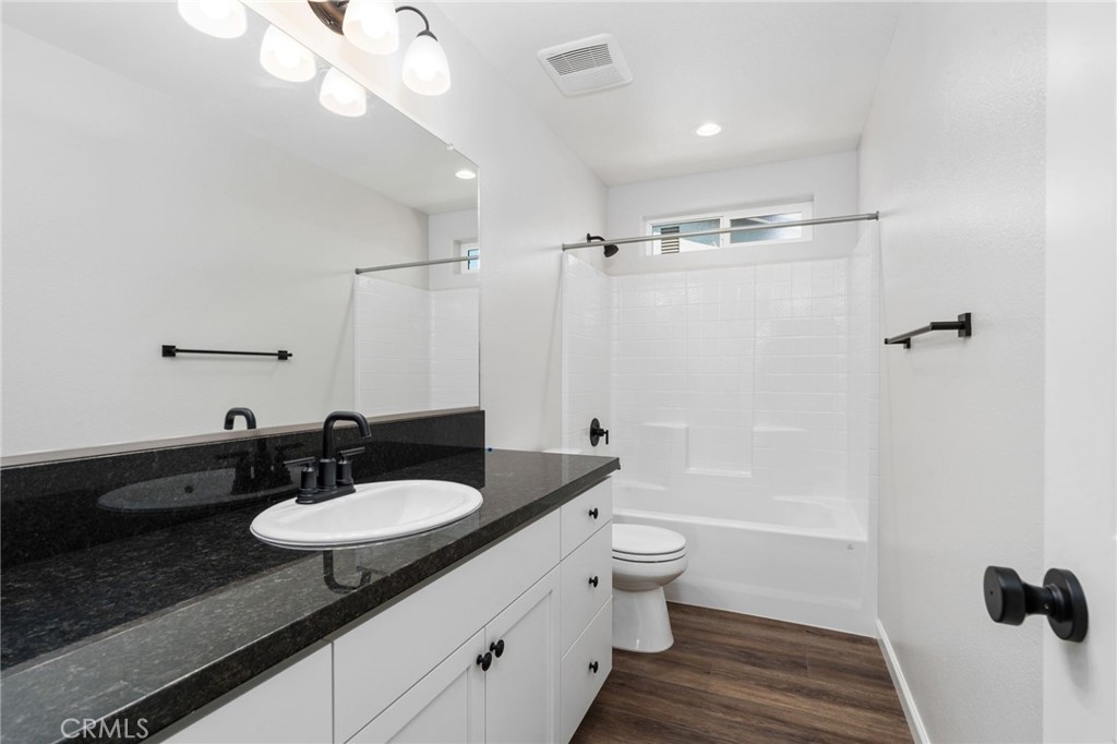 1266 Talus Way South Madera, CA 93636 - Photo 34 of 43 a bathroom with a granite countertop sink a toilet a mirror and shower