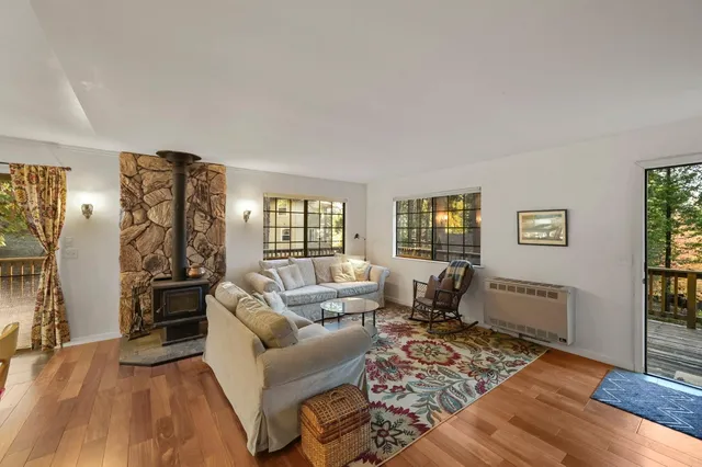a living room with furniture large window and wooden floor