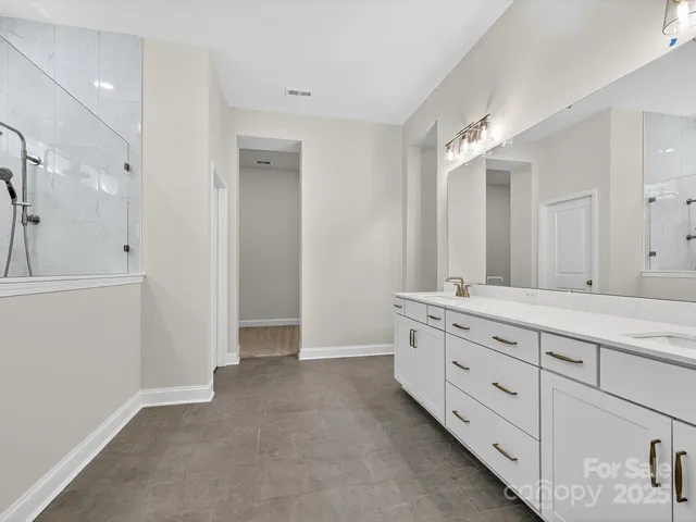 a bathroom with a granite countertop sink mirror and cabinets