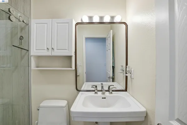 a bathroom with a sink and mirror with toilet