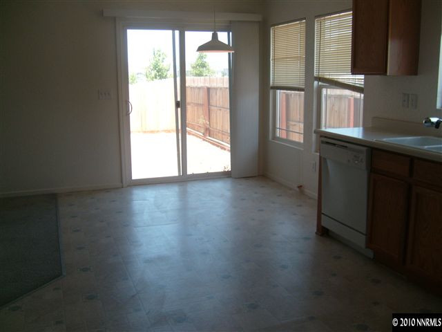 7701 Corso Street Reno, NV 89506 - Photo 2 of 8 an empty room with wooden floor and windows