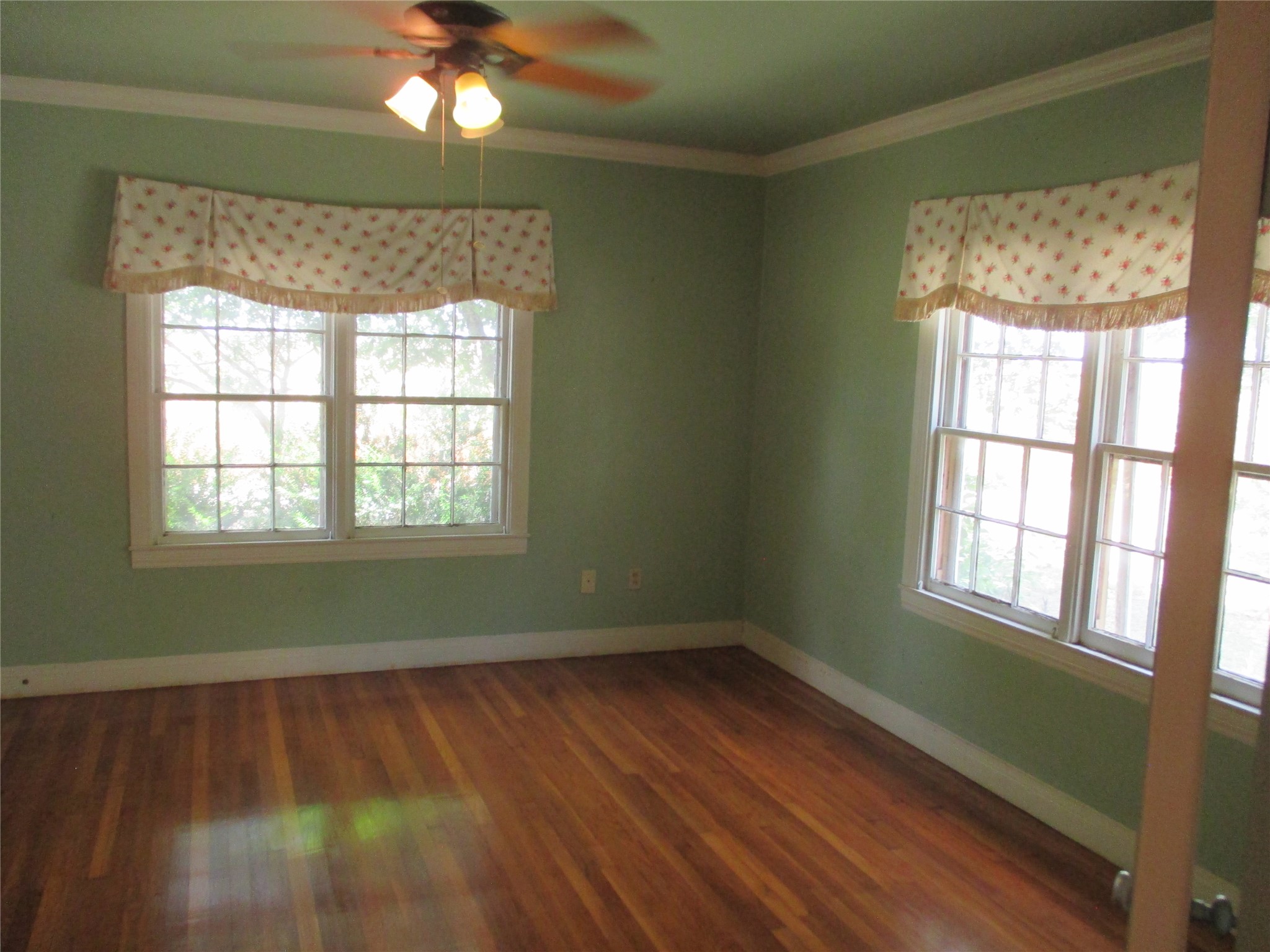 12610 Pecan School Road Bartlett, TX 76511 - Photo 11 of 21 Hardwood flooring extends throughout this naturally illuminated, verdant room, framed by multiple windows.