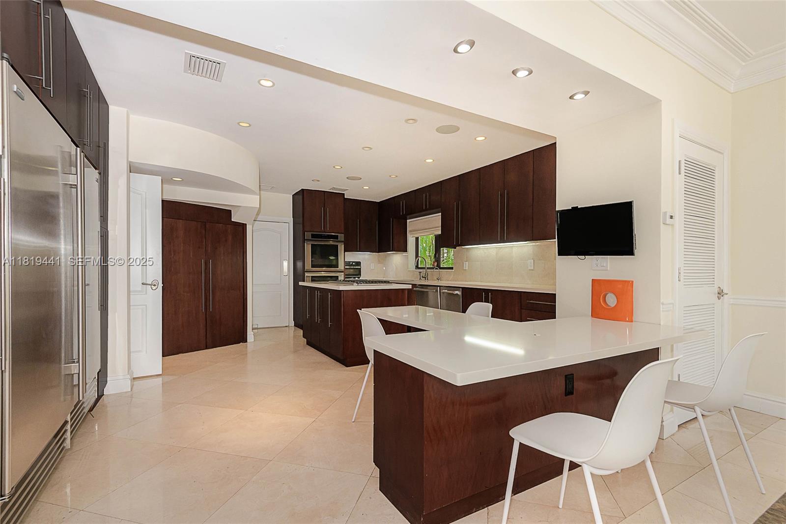 6535 Allison Road Miami Beach, FL 33141 - Photo 11 of 60 a kitchen with stainless steel appliances kitchen island a refrigerator sink and white cabinets